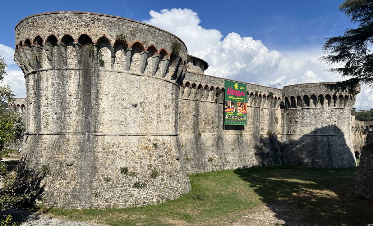 Copertina itinerario Fortaleza Firmafede: fortaleza renascentista com torres, fosso e vistas panorâmicas sobre a Lunigiana
